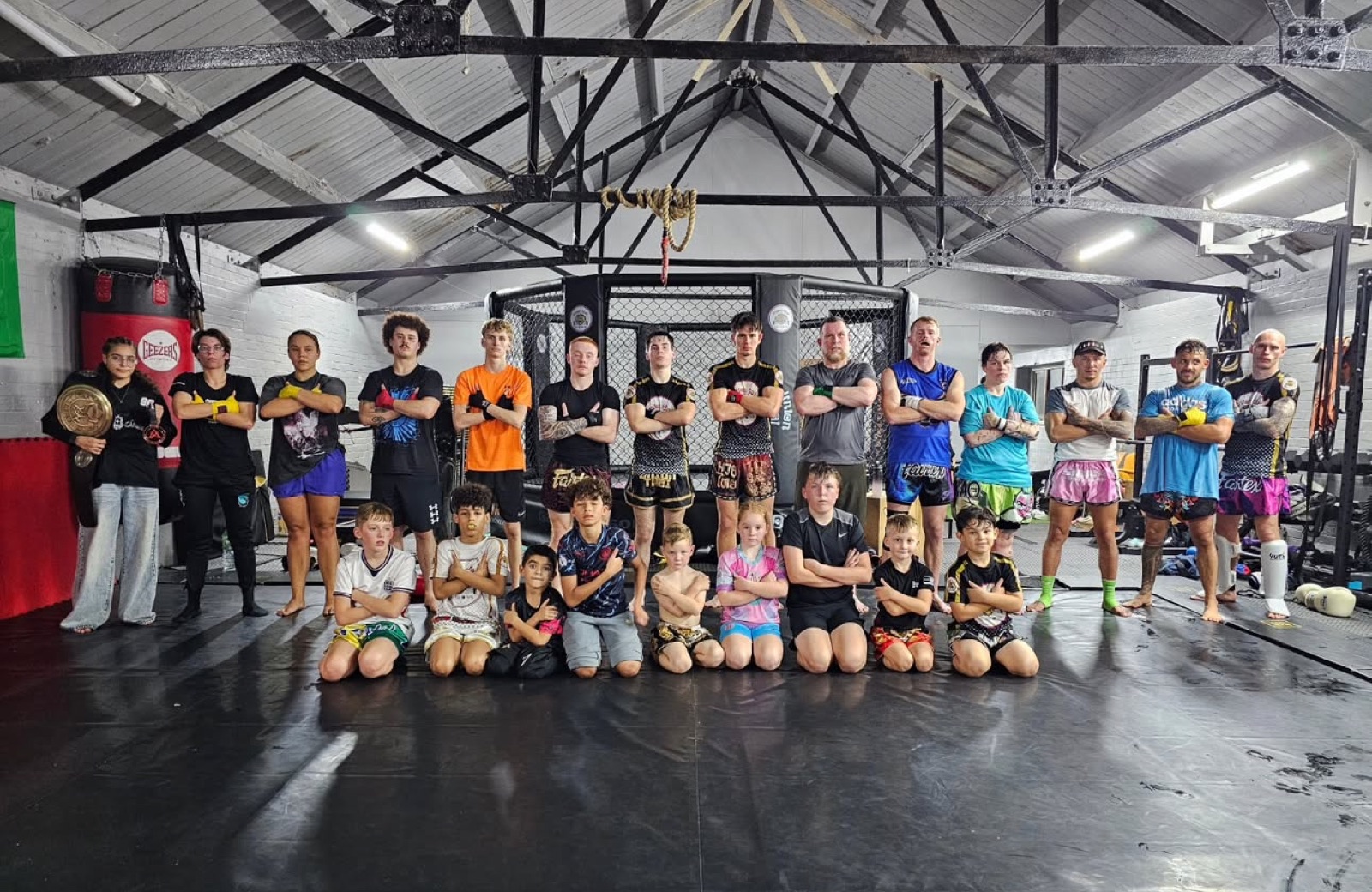 The Union Thai gym family, adults and kids, in front of the cage